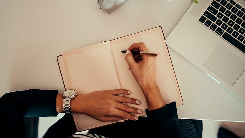 Two office buildings joined by an enclosed walkway seen from street level on an overcast afternoon.